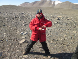 color photo of Walter Andriuzzi gathering a soil sample in Antarctica