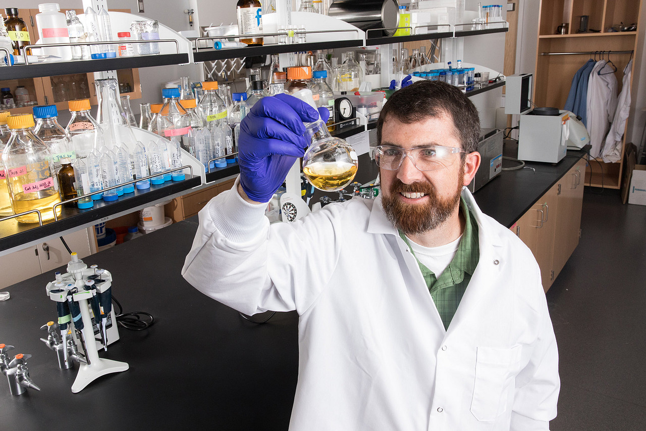 Andy Koppisch evaluates a beaker of chemicals inside a chemistry lab.
