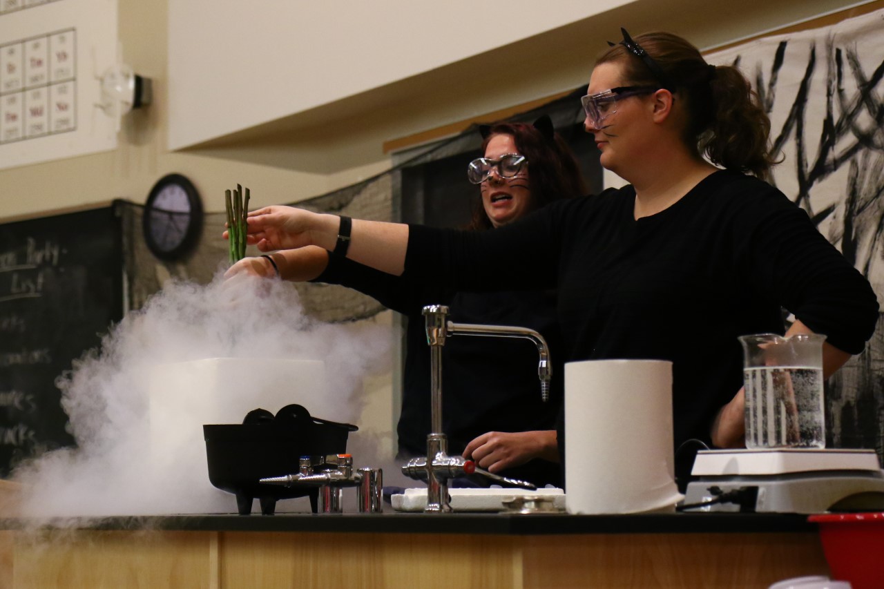 Two instructors dressed as cats do a liquid nitrogen demonstration
